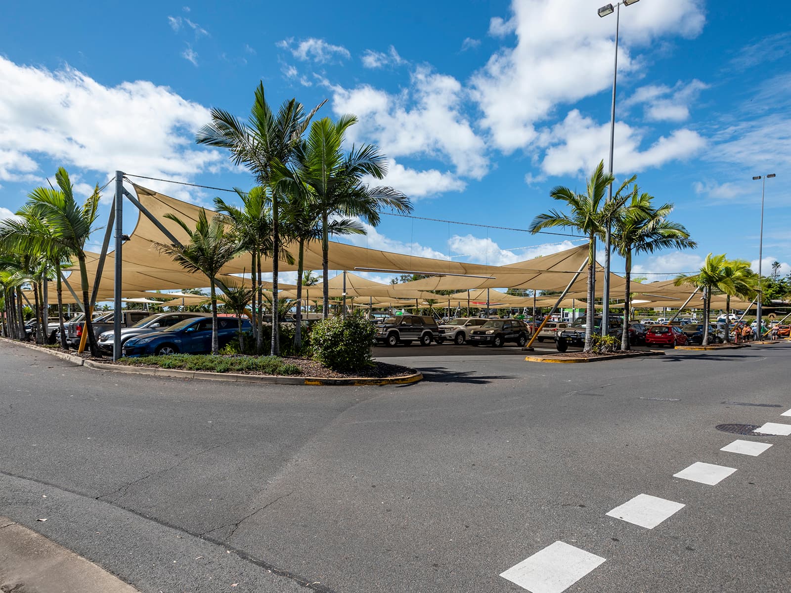 Shade sails over the Urangan Central car park with palm trees